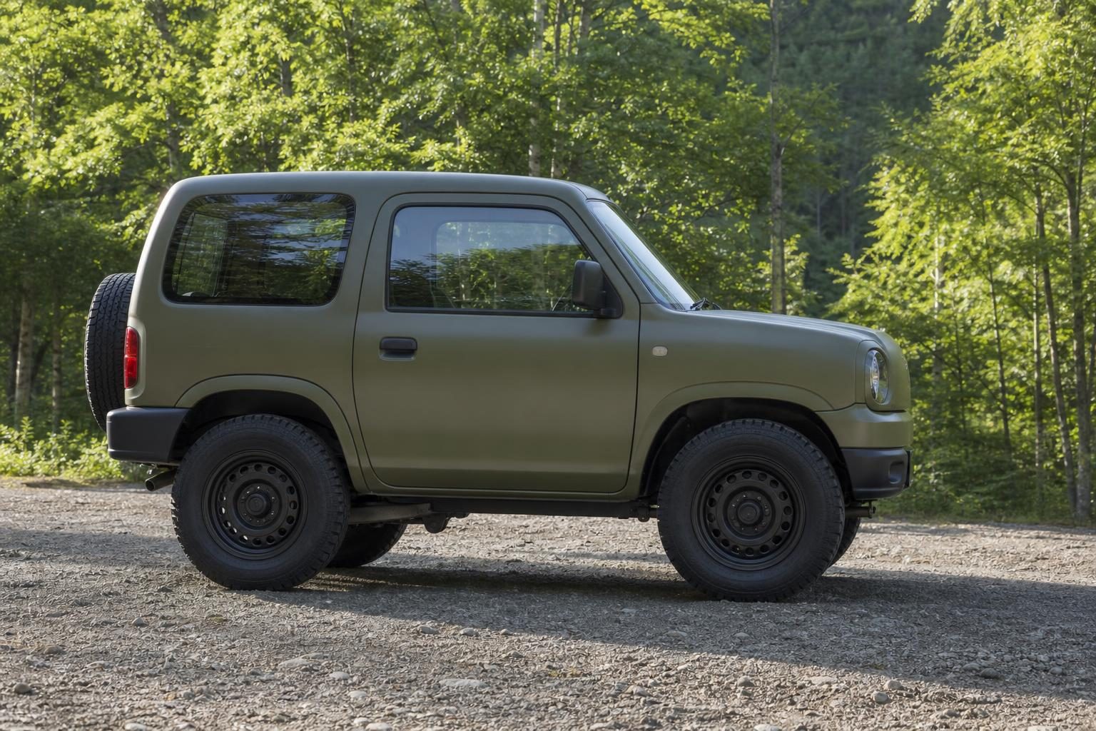 晴れた林道に停まる角ばった軽の四輪駆動車の側面。ボディーの色は落ち着いた緑。実在車種そっくりにしない、ナンバーなし