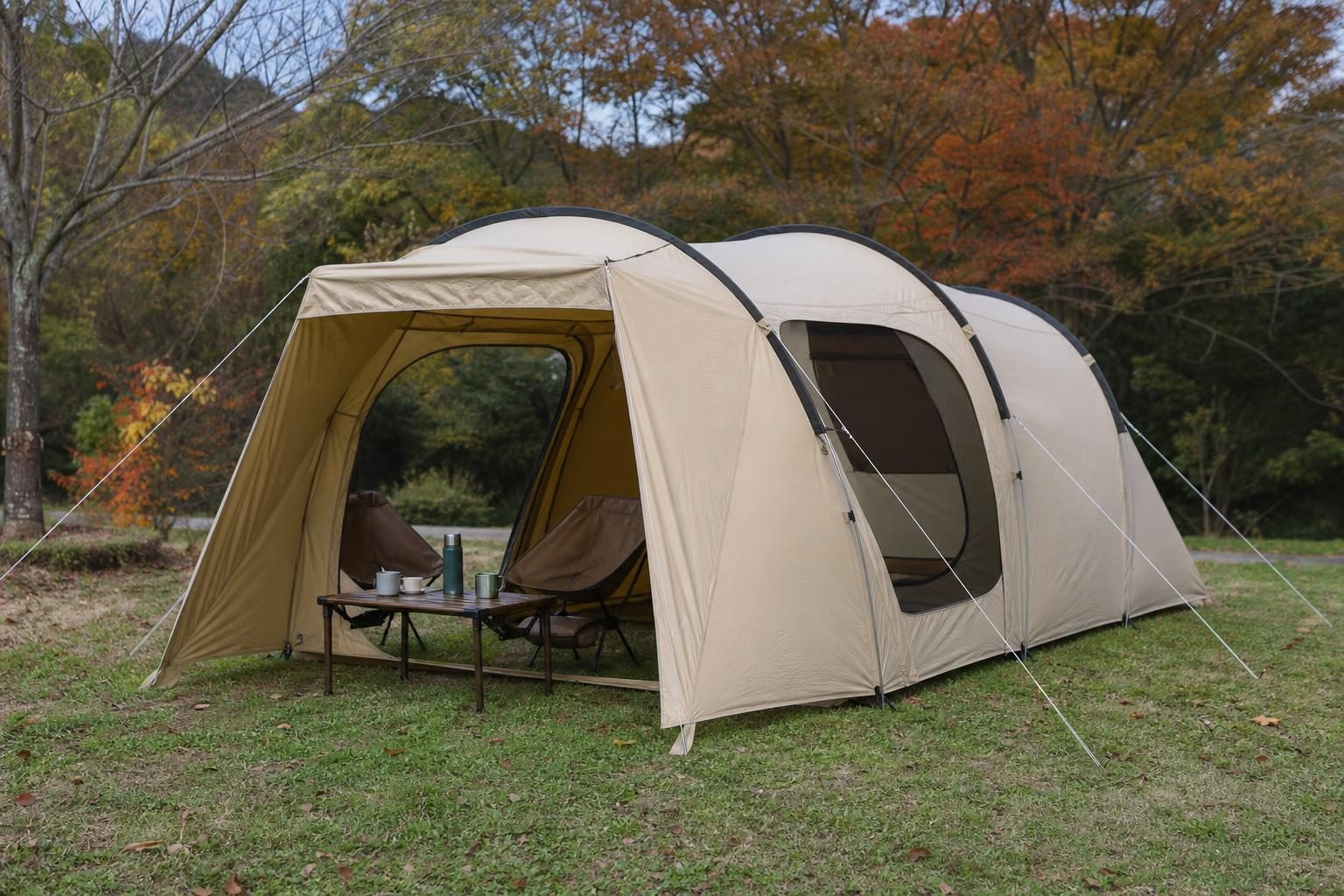 秋の芝生のキャンプサイトに張られた、ベージュ色の小型2ルームテント（寝室と前室が前後につながった形）。実在ブランドのロゴなし、火器なし